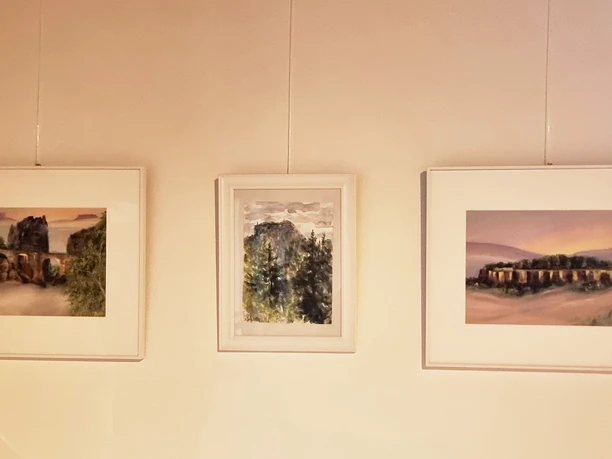 Wilde Schönheit - Malerei aus der Sächsischen Schweiz, Ausstellung in Gohrisch Gemalte Bilder der Sächsischen Schweiz an einer Wand.