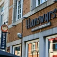Außenfassade des Restaurants "Hanswurst" mit Wandschild und großer Schrift des Namens.