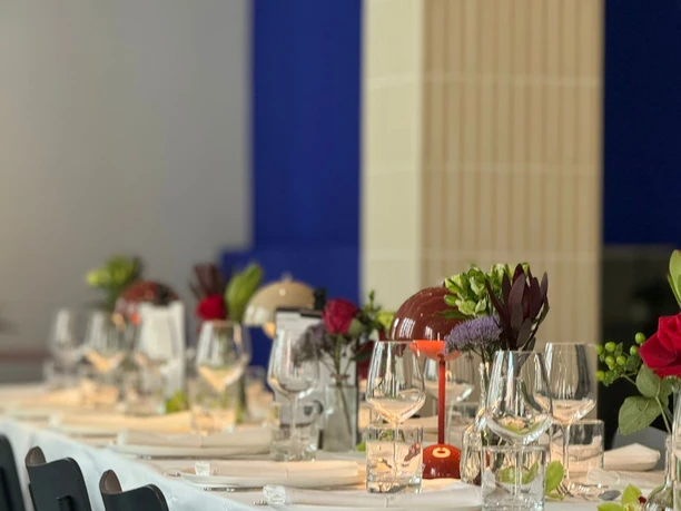 GOOSE Eventspace - Eingedeckte Tafel Eingedeckte Tafel mit schwarzen Stühlen und Blumen.
