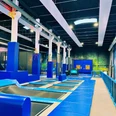 b4708411-c973-4ba9-ad02-5dd05f1a2b12 (c) Kai-Uwe Schulz_Erlebnis Bremerhaven.JPG Großer Indoor-Trampolinpark mit blauen Sprungflächen, Polstern und bunter Wandgestaltung.