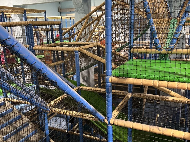 IMG_5461 (c) Erlebnis Bremerhaven.JPG Mehrstöckiger Kletter- und Spielbereich mit Netzen, Röhren und Rutschen in einer Indoorhalle.