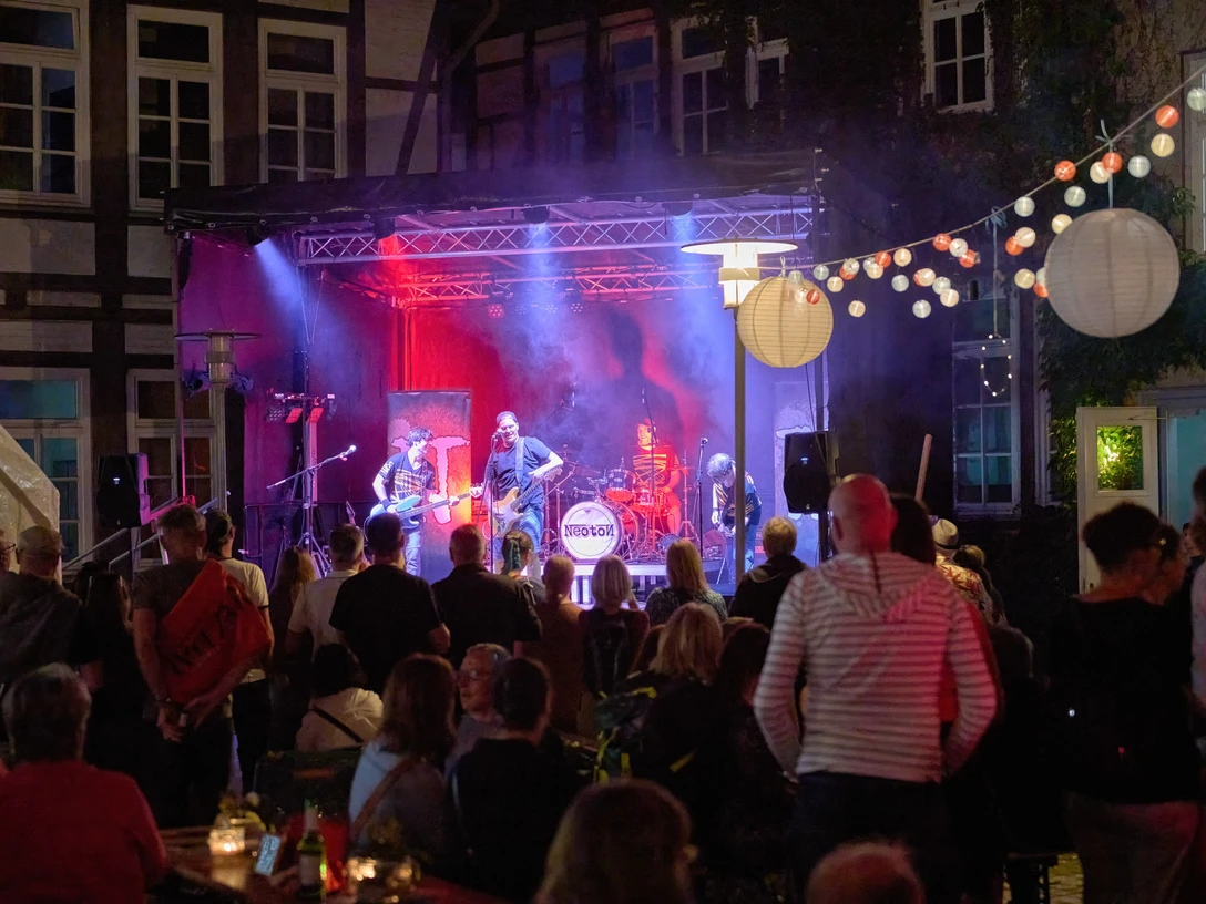 WF-Kulturnacht-BIZ 03.jpg Open-Air-Konzert bei Nacht mit Band auf Bühne und Publikum unter Lichterketten.