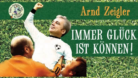 Arnd Zeigler in Fußballtrikot jubelnd auf Rasen, mit Schriftzug „Immer Glück ist Können!“