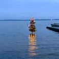 Weihnachtsbaum-im-Zwischenahner-Meer-mit-Leuchtturm-Tanne.jpg Geschmückte Weihnachtstanne mit Lichterkette steht im Zwischenahner Meer nahe des DLRG-Stegs.
