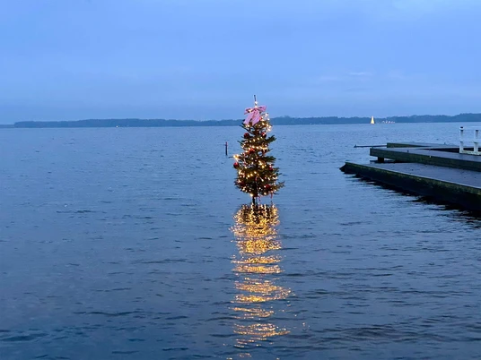 Weihnachtsbaum-im-Zwischenahner-Meer-mit-Leuchtturm-Tanne.jpg Geschmückte Weihnachtstanne mit Lichterkette steht im Zwischenahner Meer nahe des DLRG-Stegs.