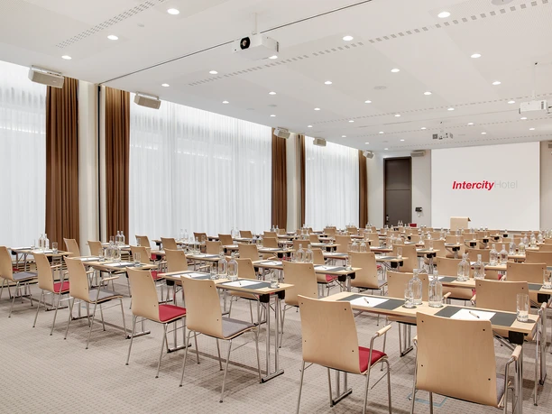 IntercityHotel Frankfurt Hauptbahnhof Süd - Conference room interior view large Large conference room with row seating, large windows and projector.