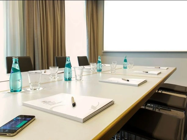 Citadines City Centre Frankfurt_3(c)Citadines Betriebs GmbH-Alle Rechte vorbehalten.jpg Ein gemütlicher Warte- oder Loungebereich mit farbenfrohen, gemusterten Sofas und einem Sessel. Eine dunkle Ablage mit Zeitschriften und ein Fenster sind ebenfalls zu sehen.