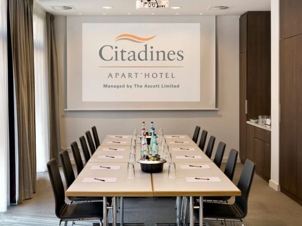 Citadines City Centre Frankfurt - Conference room A professional conference room with a long table, chairs and a screen displaying the "Citadines APART' HOTEL" logo.