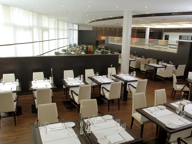 NH Frankfurt Airport West - Restaurant Ein Restaurant oder Speisesaal in einem Hotel, vermutlich im NH Frankfurt Airport West. Der Raum hat eine moderne Einrichtung, Tische sind für Gäste eingedeckt.