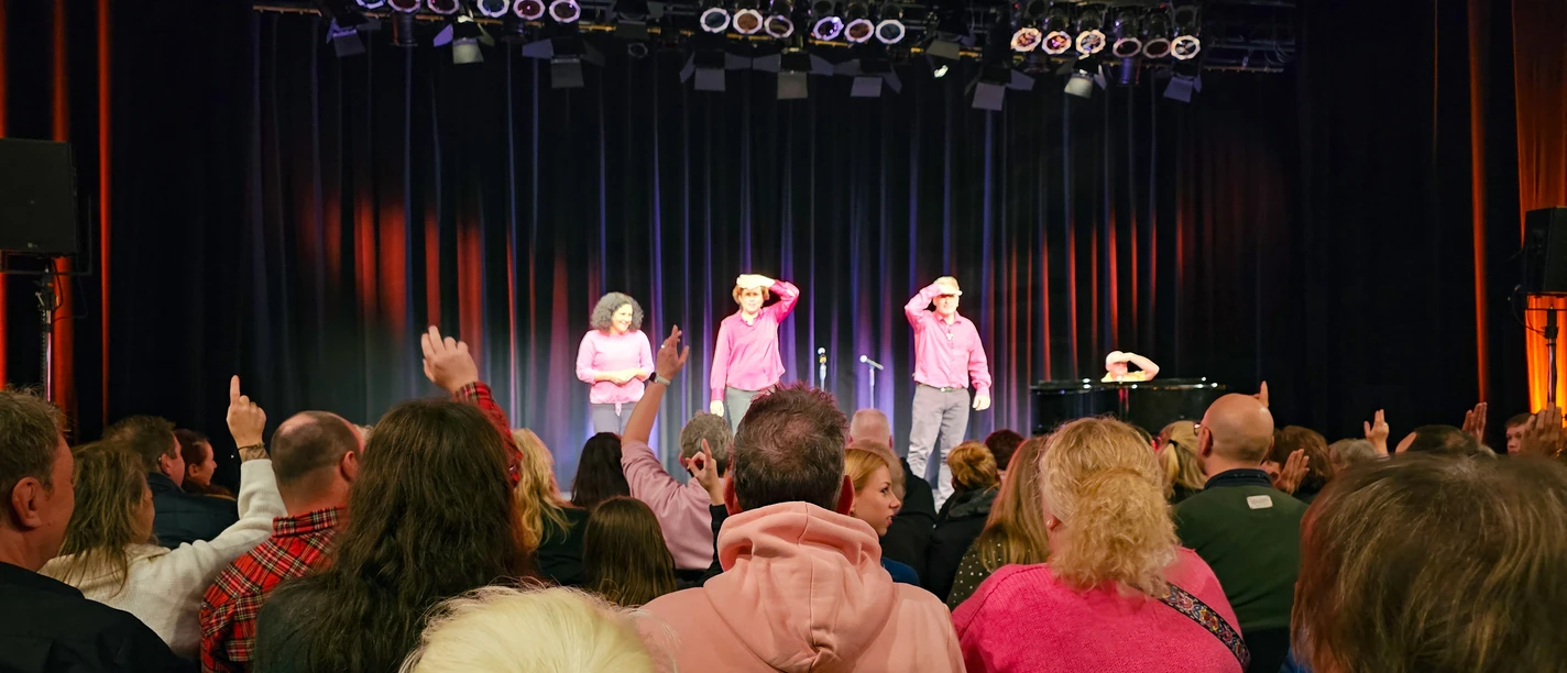 Publikum lacht und applaudiert bei einer Live-Aufführung im TiF Theater im Fischereihafen Bremerhaven.