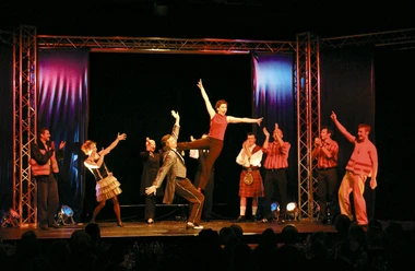 Theater im Fischereihafen 5.jpg Bunt beleuchtete Bühnenszene mit tanzender Gruppe im Theater im Fischereihafen Bremerhaven