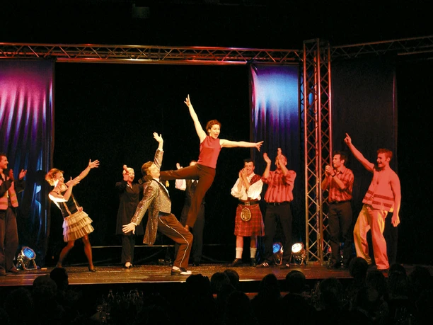 Theater im Fischereihafen 5.jpg Bunt beleuchtete Bühnenszene mit tanzender Gruppe im Theater im Fischereihafen Bremerhaven