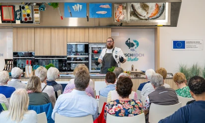 © Björn Hake.jpg Koch erklärt vor Publikum die Zubereitung von Fischgerichten in moderner Studioküche in Bremerhaven.