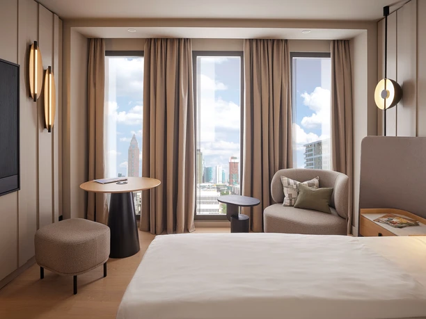 ATLANTIC Hotel Frankfurt - Hotelzimmer Modernes Hotelzimmer mit Cityblick und Sitzecke