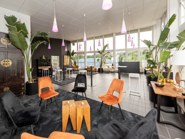 LOFT By CKE - Upper Main Heller Raum mit lila Pendelleuchten, gepolstertem Stühlen und schwarze Teppiche.