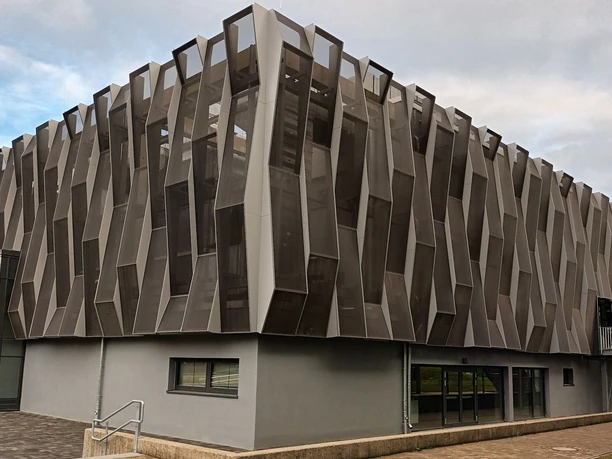 Moderne Aula mit markanter, geometrischer Fassade aus Metall und Glas am Gymnasium Am Fredenberg.