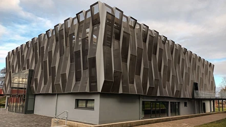 Moderne Aula mit markanter, geometrischer Fassade aus Metall und Glas am Gymnasium Am Fredenberg.