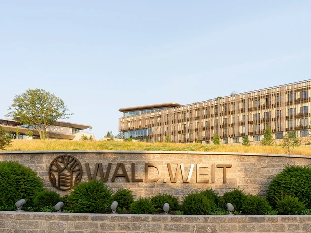WALD.WEIT Rheingau Hotel & Retreat - Aussenansicht Aussenansicht des Hotels in ruhiger, grüner Hanganlage mit Hotellogo im Vordergrund.