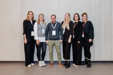 Time Change GmbH Ein Team von sechs Personen steht nebeneinander und lächelt in die Kamera.