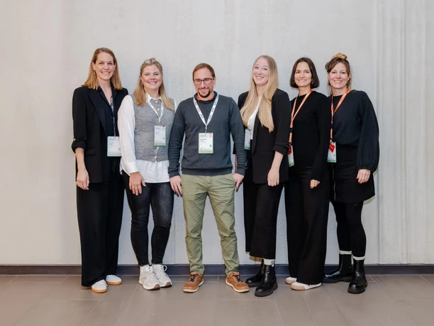 Time Change GmbH Ein Team von sechs Personen steht nebeneinander und lächelt in die Kamera.