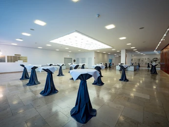 Location Rhein-Main - modernes Foyer Helles, modernes Foyer mit Stehtischen und Marmorboden, eingerichtet für einen Empfang.