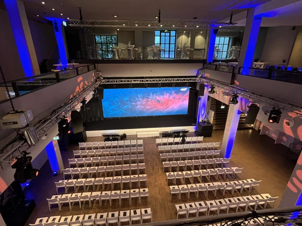 Union Halle - Innenansicht Moderne Eventhalle mit Galerie, LED-Leinwand und Reihenbestuhlung.