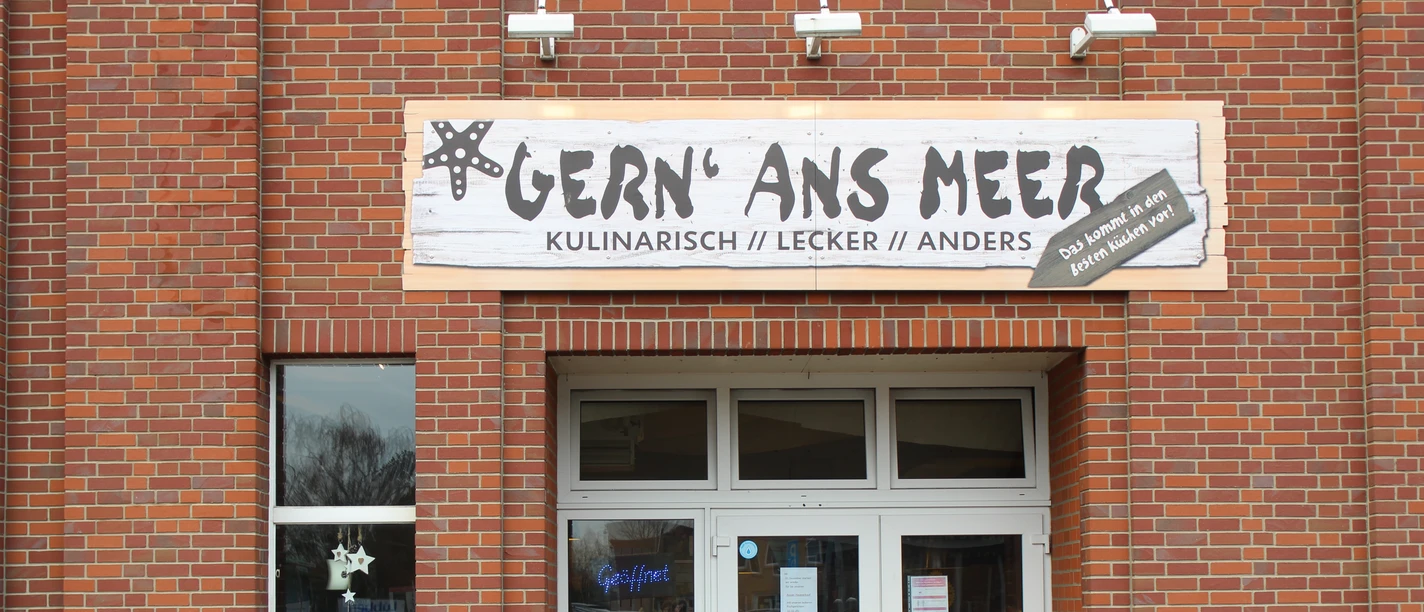 Gern ans Meer IMG_8181 (c) Jasmin Emilia Meyer_Erlebnis Bremerhaven.JPG Backsteinfassade mit Eingang des Fischimbisses Gern’ Ans Meer und Tafeln mit Speisenangebot.