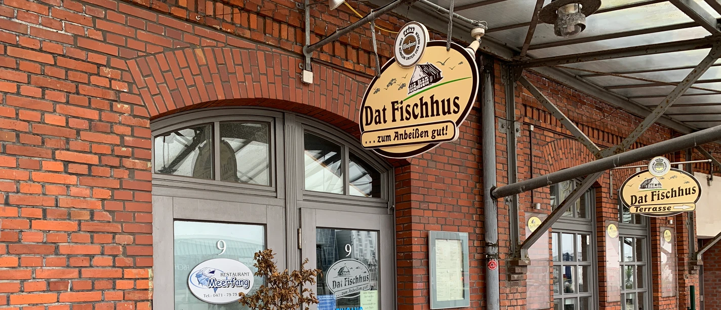 Dat Fischhus IMG_3482 (c) Jasmin Emilia Meyer_Erlebnis Bremerhaven.JPG Eingang des Restaurants Dat Fischhus in rotem Backsteingebäude mit überdachter Terrasse.
