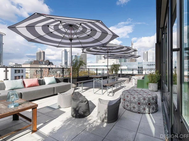 Design Offices Frankfurt Wiesenhüttenplatz - Terrasse Großflächige Terrasse mit Beistelltisch, großen Sonnenschirmen, Sofa und Sitzsäcken.