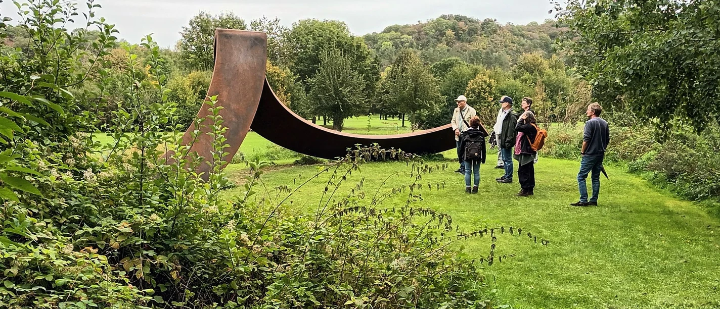 2023_Herbstspaziergang (2)_HD_16zu9.jpg Group on a guided tour in front of a large steel sculpture on the golf course in Salzgitter-Bad in the fall