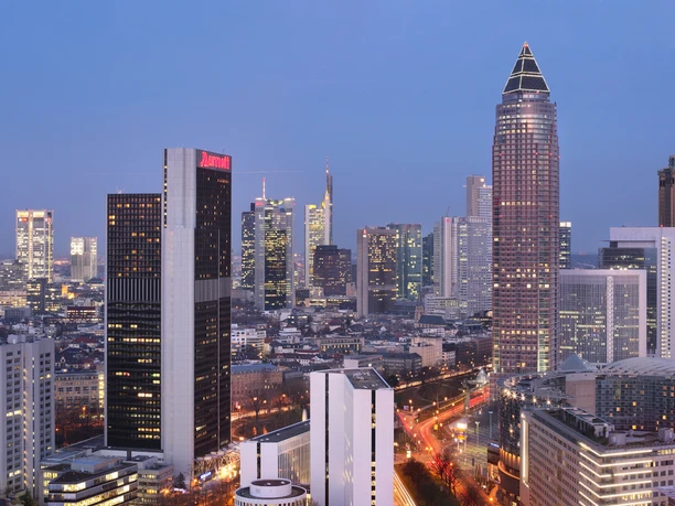 Frankfurt Marriott Hotel - Außenansicht Nächtliche Skyline von Frankfurt mit dem beleuchteten Messeturm und dem Marriott Hotel im Vordergrund.