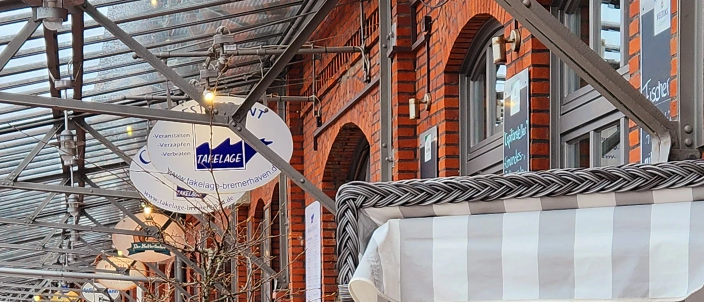 20240324_121757 (c) Dagmar Brandenburg_Erlebnis Bremerhaven.jpg Außenterrasse mit Strandkorb und gedecktem Tisch vor roter Backsteinfassade in Bremerhaven