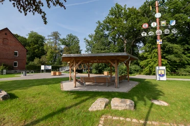 Rastplatz am Heubach in Vinsebeck Holzpavilion mit Sitzbänken, daneben ein Maibaum, Rastplatz direkt am Heubach