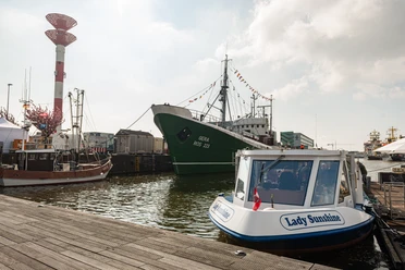 Mehrere Schiffe liegen im Bremerhavener Fischereihafen, im Vordergrund das Fahrgastboot Lady Sunshine.