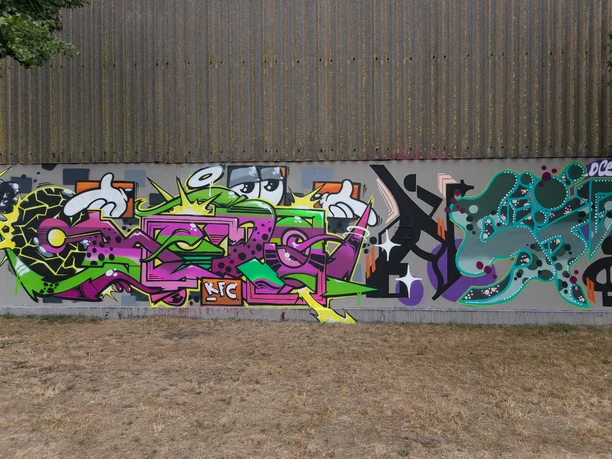 Graffiti in Bremerhaven N6848 (c) Helmut Gross_Erlebnis Bremerhaven.jpg Bunte Graffitiwand in Bremerhaven mit abstrakten Formen und kräftigen Farben auf grauem Hintergrund