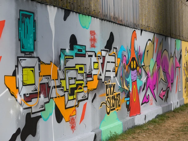 N6839 (c) Helmut Gross_Erlebnis Bremerhaven.jpg Bunte Graffitiwand in Bremerhaven mit abstrakten Formen, Schriftzügen und einer Figur in kräftigen Farben.