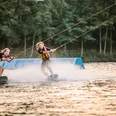 Wakeborden in bei Wasserski Langenfeld Zwei lachende Wakeboarderinnen gleiten über das Wasser bei Wasserski Langenfeld, spritzende Wellen.