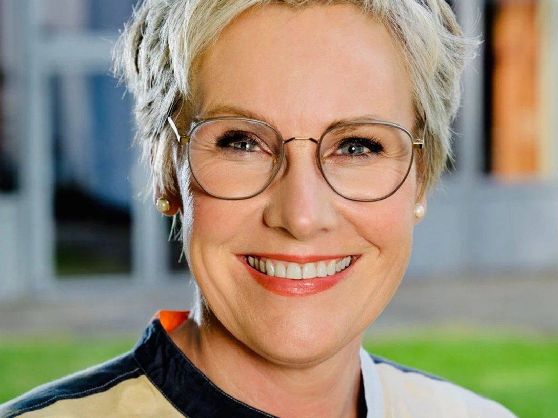 Vortrag für Frauen mit Elisabeth Stange Eine lächelnde Person mit Brille in farbigem Oberteil vor unscharfem Hintergrund. Das Bild zeigt Elisabeth Stange