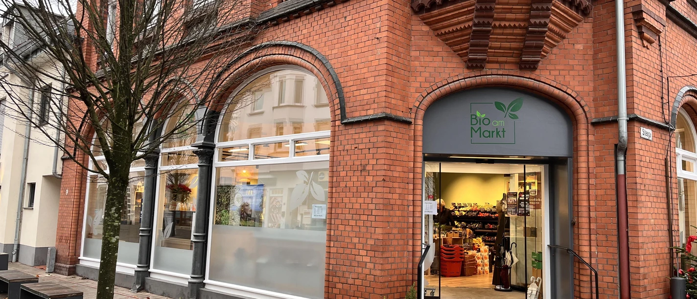Eingang von Bio am Markt in rotem Backsteinhaus mit Rampe und Schaufenstern