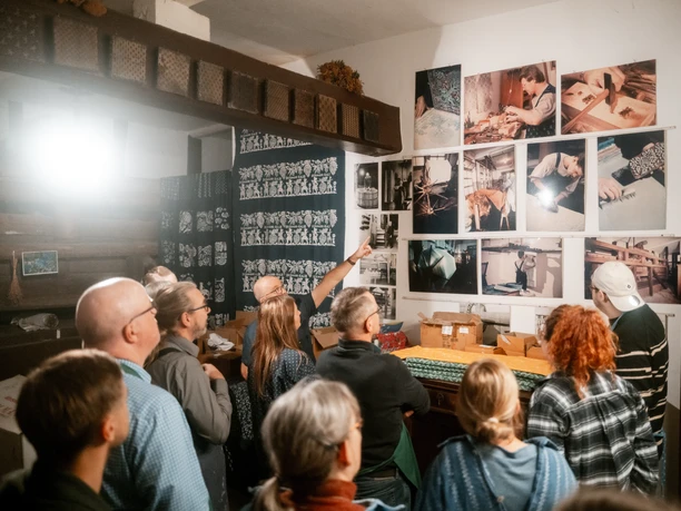 Blaudruck Workshop Menschen folgen einer Führung zum traditionellen Blaudruckhandwerk in einem Workshopraum.