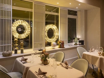 Sahila Ein Speiseraum mit eleganten Tischdecken und gemütlicher Beleuchtung.A dining room with elegant tablecloths and cozy lighting.