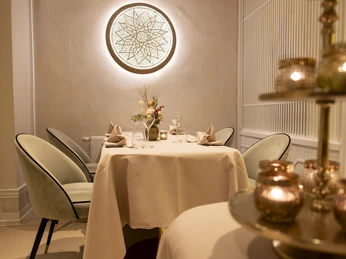 Sahila Ein elegant gedeckter Tisch mit frischen Blumen.An elegantly laid table with fresh flowers.