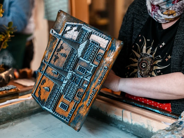 Blaudruck Workshop Person druckt mit Holzmodel auf Stoff bei einem Blaudruck-Workshop in Einbeck.