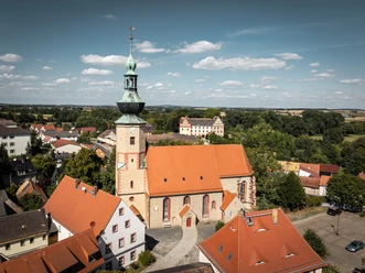 Městský kostel v Trebsenu, pohled zvenčí na věž a historické průčelí, pohled na okolní město.