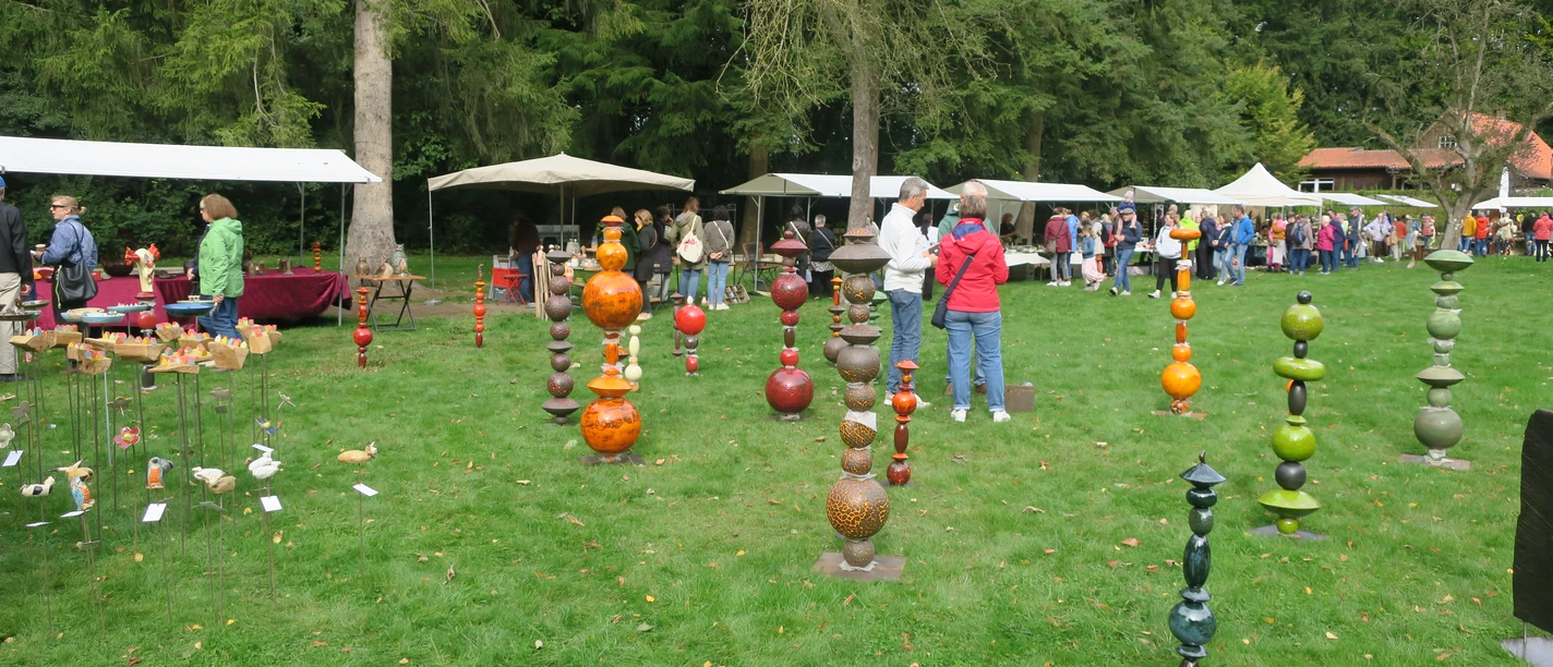 Töpfermarkt.JPG Besucherinnen und Besucher schlendern über einen Töpfermarkt mit bunten Keramikkunstwerken im Freien.