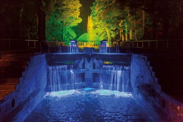 1509-lichterfest.jpg Leuchtender Wasserfall und bunt angestrahlte Bäume bei Nacht während des Lichterfests in Meppen.