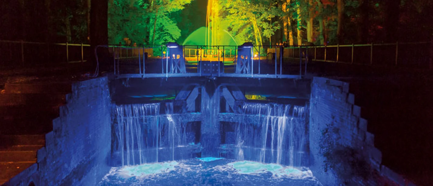 1509-lichterfest.jpg Leuchtender Wasserfall und bunt angestrahlte Bäume bei Nacht während des Lichterfests in Meppen.