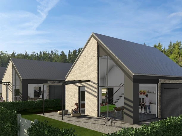 Hausansicht Hinten.jpg Moderne Ferienhäuser mit hohen Giebeldächern, großen Glasfronten und Terrasse vor grüner Kulisse