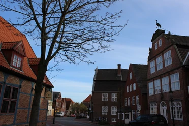 Kranichhaus Otterndorf © Stadt Otterndorf Straße mit alten Backsteinhäusern in Otterndorf. Auf einem Haus steht eine Storchenfigur.