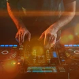 Closeup of a DJ working under the lights against a dark background in a studio Closeup of a DJ working under the lights against a dark background in a studio